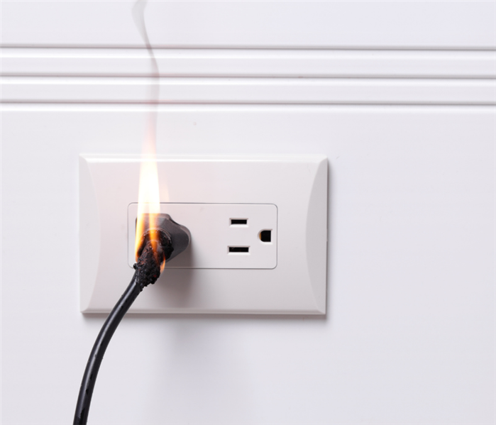  electrical cord in wall outlet on fire